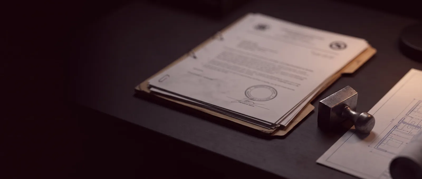 Pasta com documentos assinados e carimbados sobre uma mesa escura, ao lado de um carimbo e de uma planta